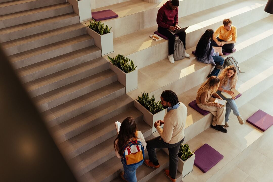 Web_Desktop-University students collaborating and studying in modern campus area