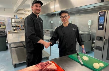 ISS chefs shaking hands in ISS kitchen